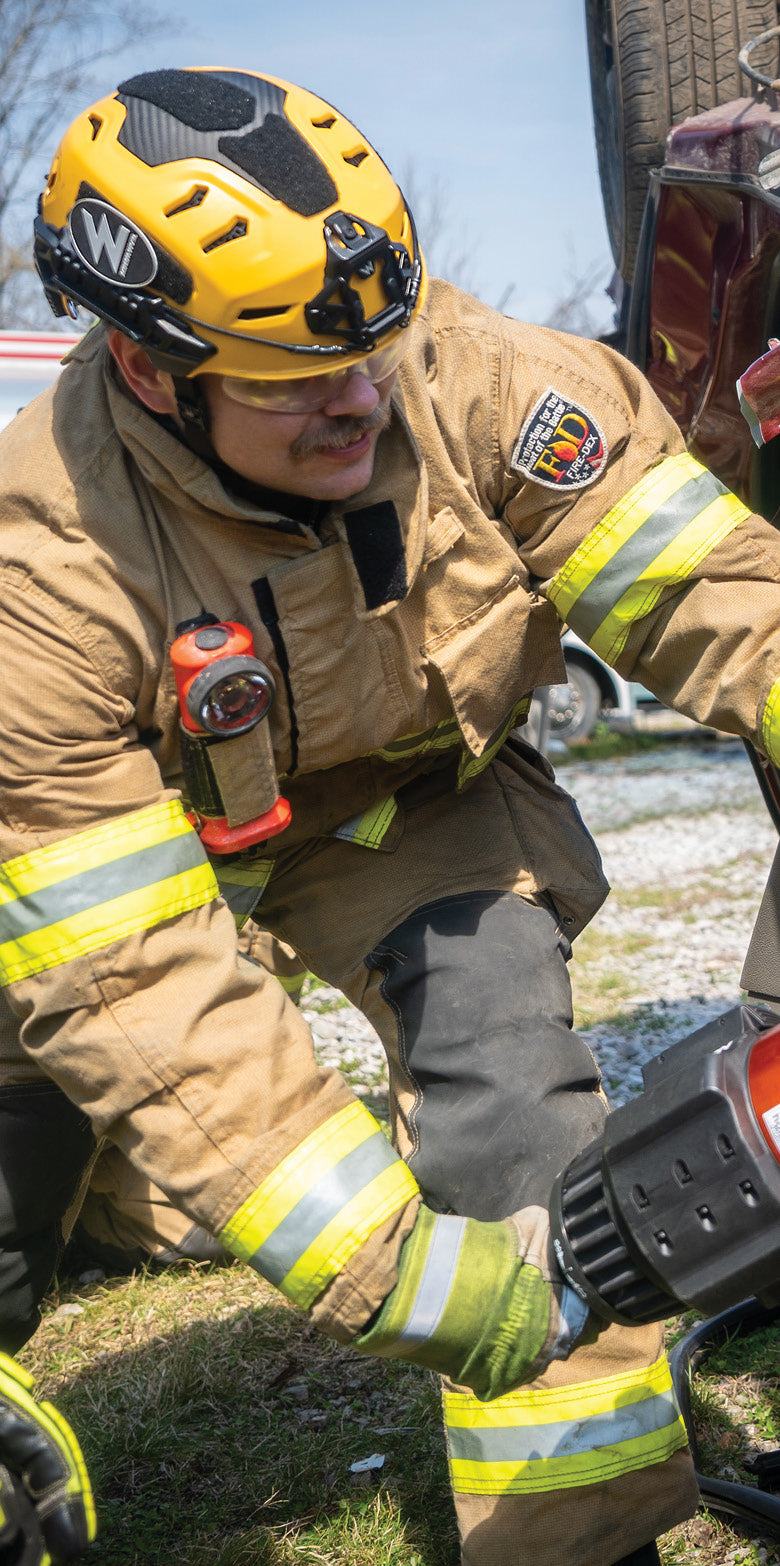 A firefighter wearing a Team Wendy RECON Tactical helmet during a vehicle extrication. 